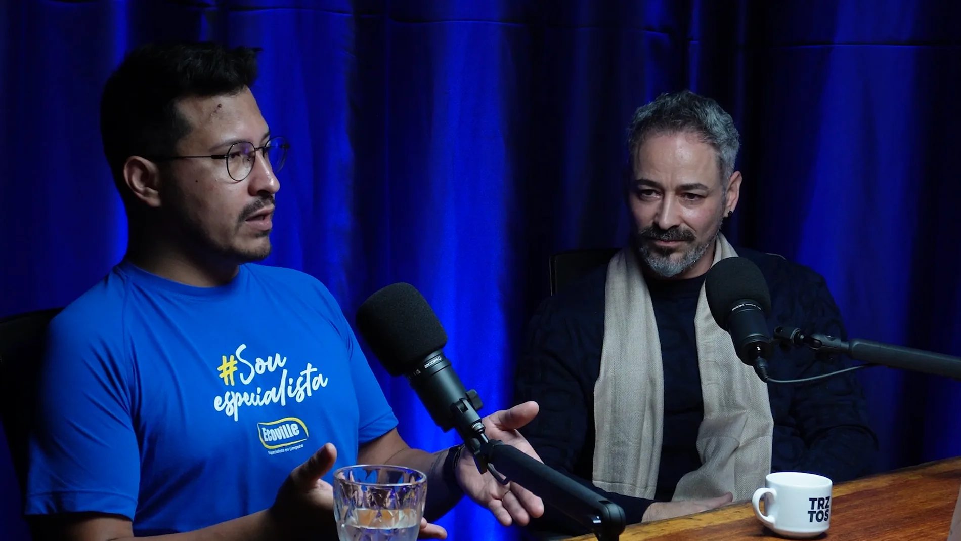 Participantes em gravação de podcast com microfones